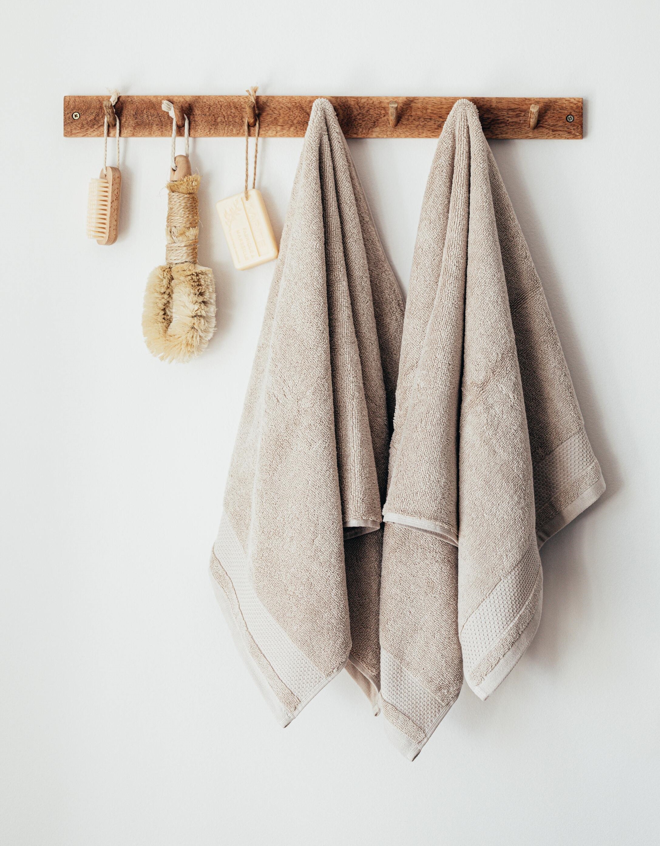 Cepillos de baño, jabones y toallas de baño colgadas de una pared